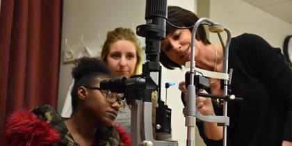 Students examining Optic Device